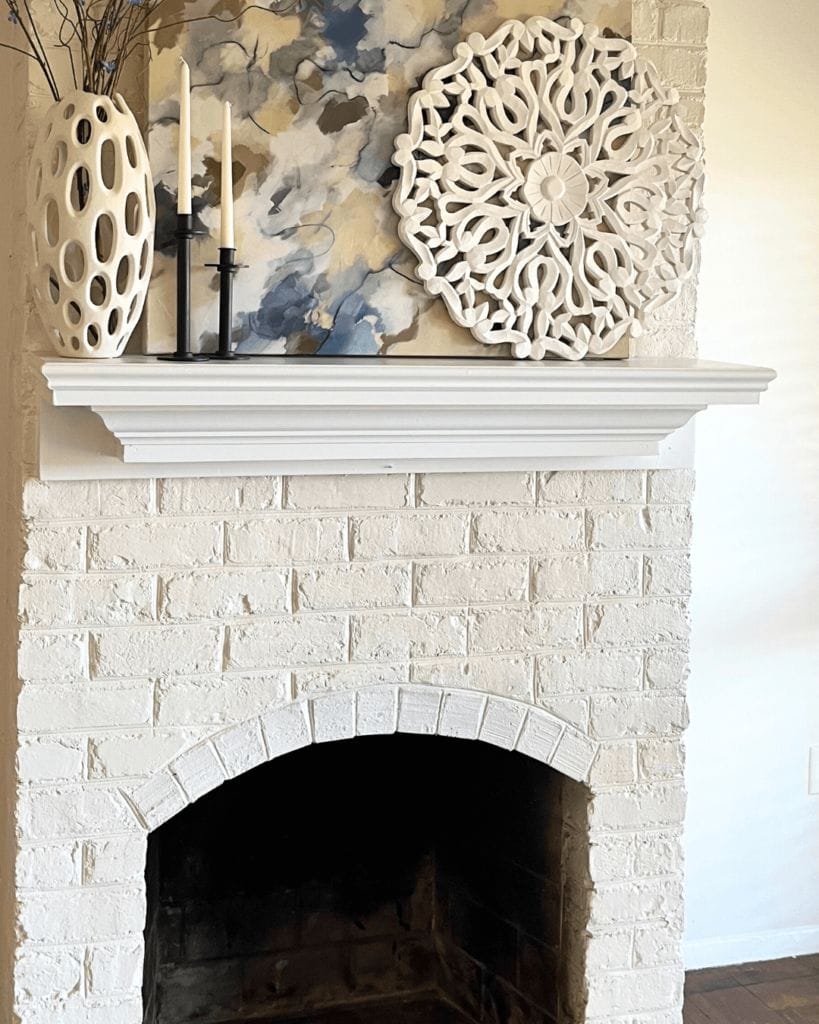 white washed fireplace with simple decor on mantle